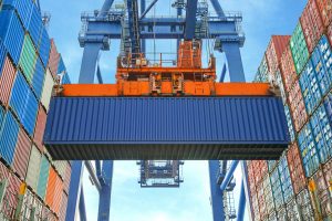 A large crane lifts a shipping container